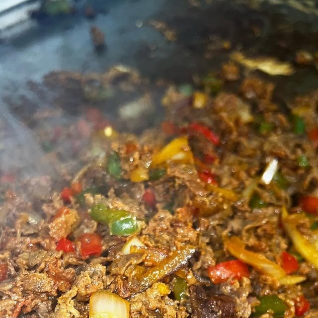 Sizzling steak and peppers on the grill at Dyckman Cafe and Grill